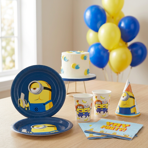 akalikų (Minions) gimtadienio stalas su teminėmis lėkštutėmis, puodeliais, servetėlėmis, kepurėle, tortu ir balionais.